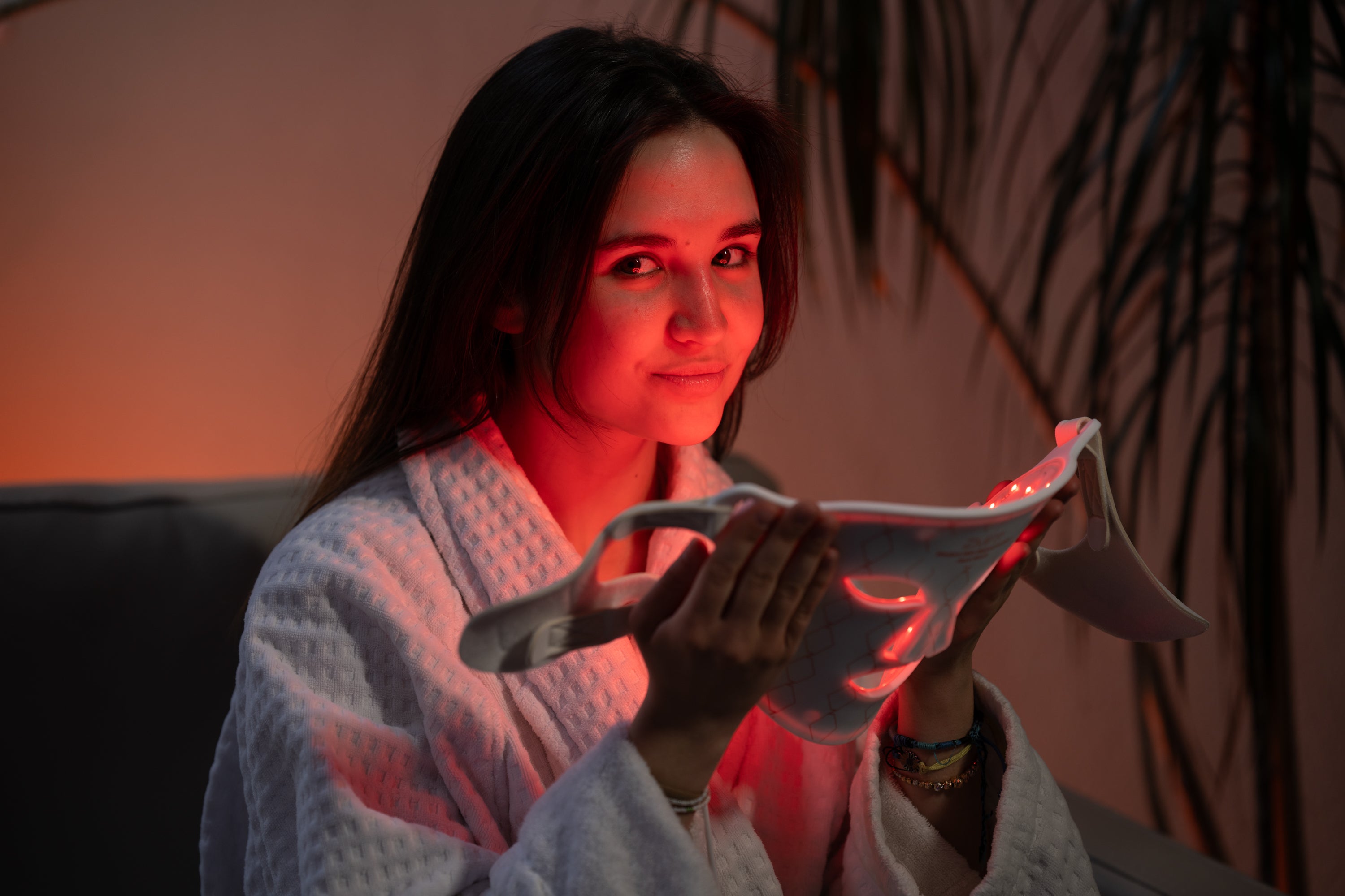 Woman using NV GlowLift red light gua sha on face for sculpting and lifting